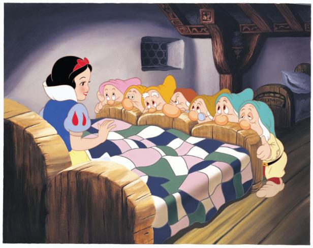 Szene aus dem Film „Schneewittchen und die sieben Zwerge“, in der Schneewittchen am Bett der Zwerge steht.
