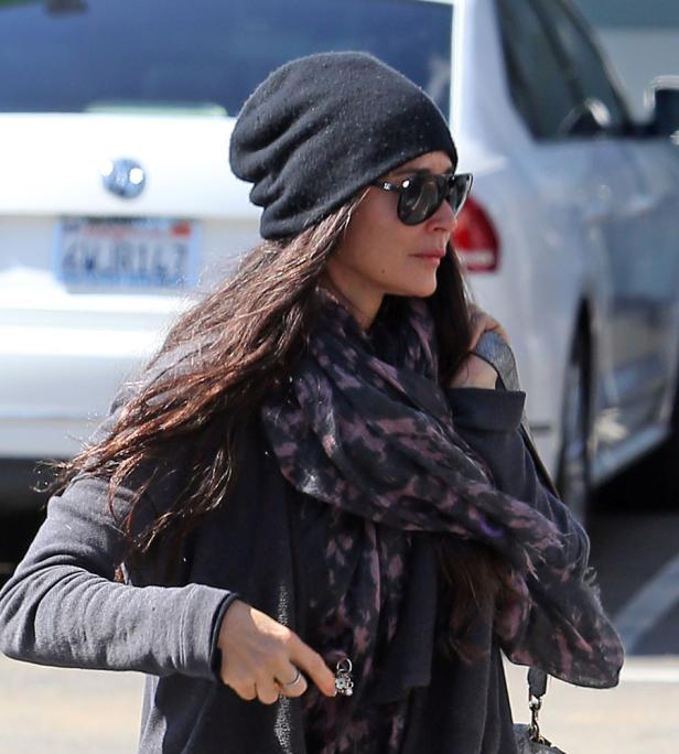 Eine Frau mit Sonnenbrille und Mütze trägt einen Schal.