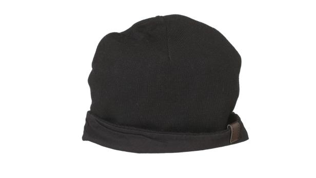 Eine schwarze Strickmütze liegt vor einem weißen Hintergrund.