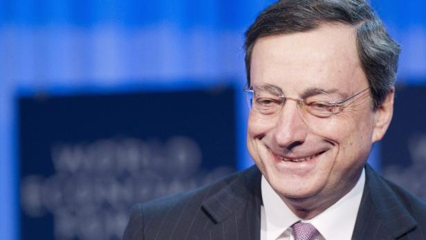Mario Draghi lächelt vor einem blauen Hintergrund.