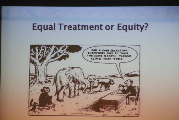 Eine Karikatur zeigt verschiedene Tiere, die vor einem Baum stehen, während ein Prüfer sie auffordert, auf den Baum zu klettern.