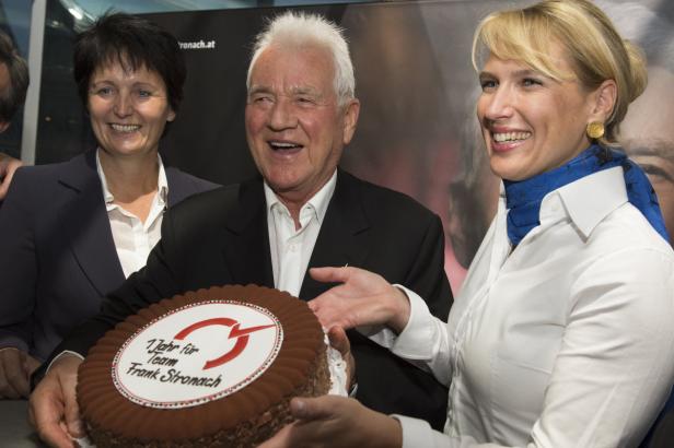 Frank Stronach feiert mit zwei Frauen eine Torte zum 1-jährigen Bestehen seines Teams.