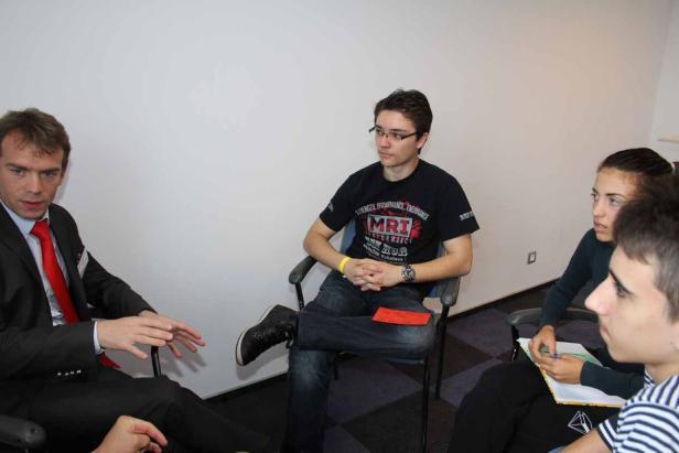 Eine Gruppe von Personen sitzt in einem Besprechungsraum.