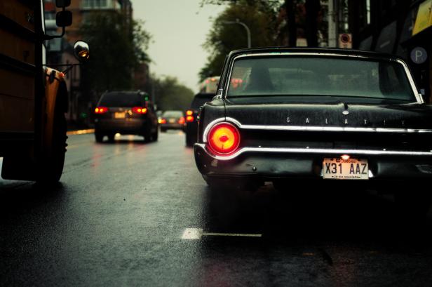 Ein schwarzer Oldtimer der Marke Ford Galaxie steht im Regen.