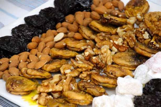 Eine Platte mit Trockenpflaumen, Mandeln, Feigen, Walnüssen und Türkischem Honig.