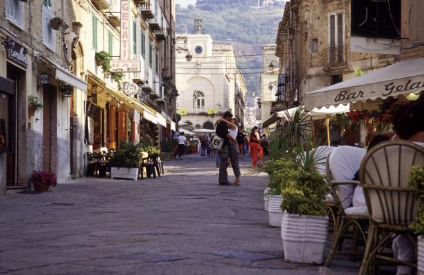 Ein Paar umarmt sich auf einer belebten Straße in einer italienischen Stadt.