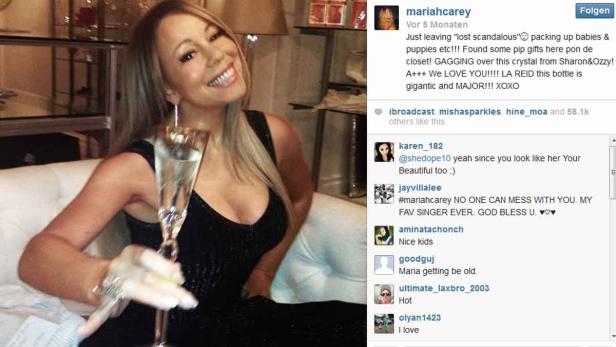 Mariah Carey posiert mit einem Champagnerglas in der Hand.