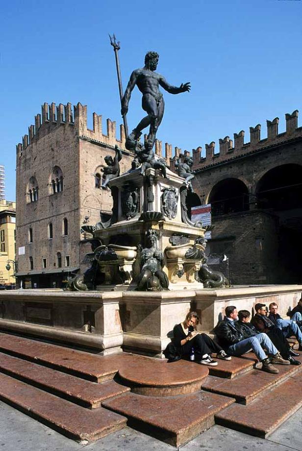 Der Neptunbrunnen in Bologna, Italien, mit Menschen, die auf den Stufen sitzen.