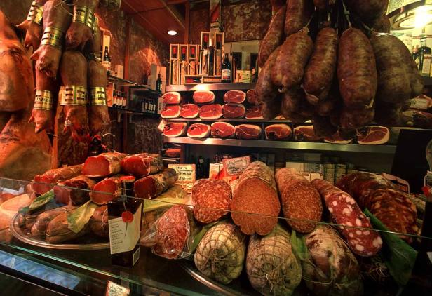 Eine Auslage mit verschiedenen Wurst- und Schinkensorten in einem Feinkostgeschäft.