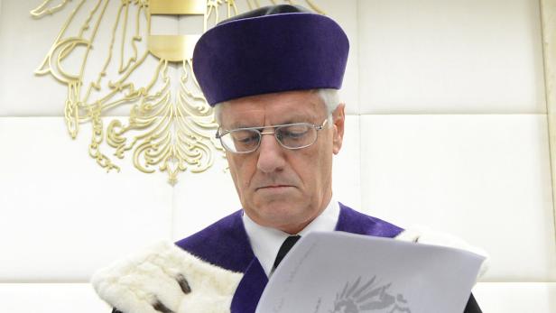 VfGH-Präsident Holzinger Ein Richter mit Brille und Talar liest ein Dokument.