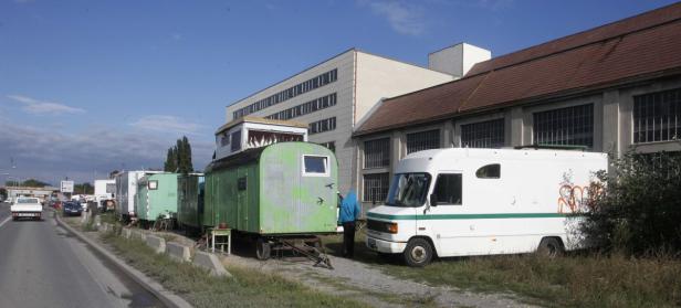 Eine Reihe von Wohnwagen und ein Wohnmobil stehen am Straßenrand.