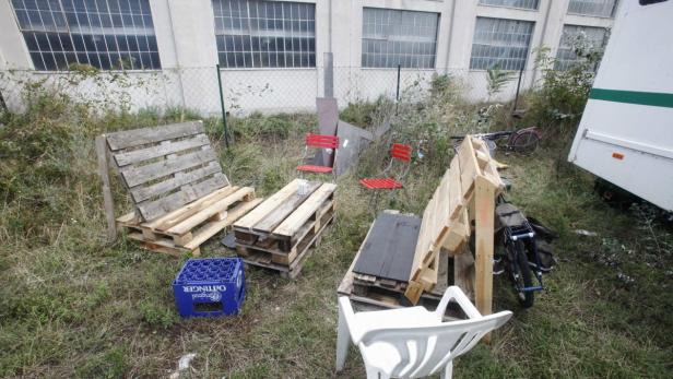 Im Gras stehen Möbel aus Paletten, zwei Fahrräder und eine Kiste Oettinger Bier.