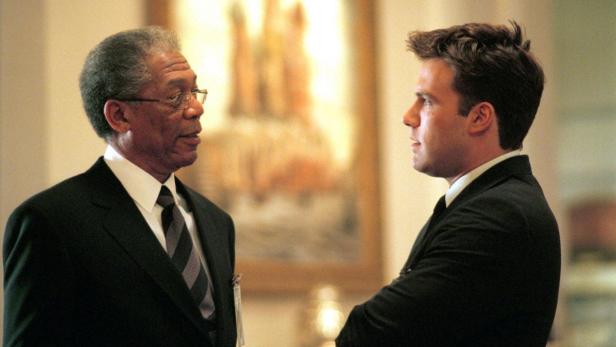 Morgan Freeman und Ben Affleck in formeller Kleidung unterhalten sich.
