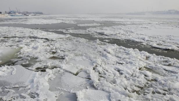 Die Donau ist vielerorts gesperrt Eisschollen treiben auf einem Fluss an einem trüben Wintertag.