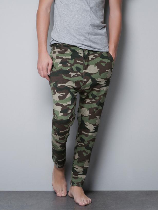 Eine Person trägt eine Tarnhose und ein graues T-Shirt.