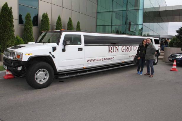 Ein Paar posiert vor einer weißen Hummer-Limousine der „RIN Group“.
