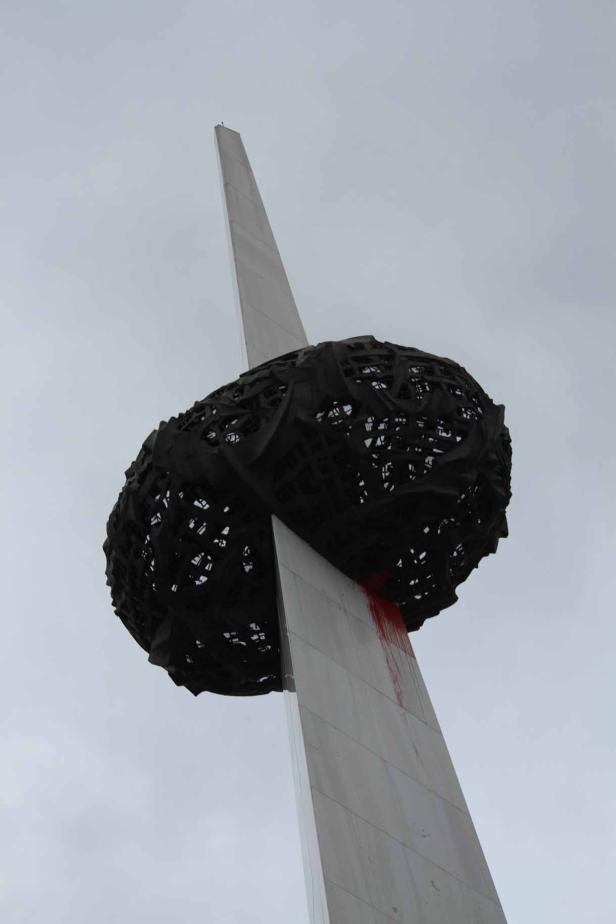 Das Denkmal der Wiedergeburt in Bukarest, Rumänien, vor einem grauen Himmel.