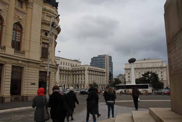 Eine Gruppe von Menschen geht über einen Platz in Bukarest, Rumänien.
