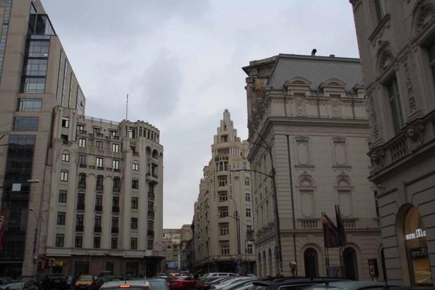 Blick auf eine belebte Straße mit verschiedenen Gebäuden in einer Stadt.