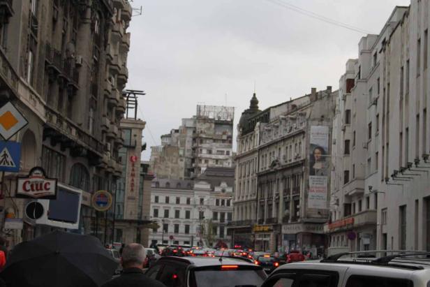 Eine belebte Straße in einer Stadt mit vielen Autos und hohen Gebäuden.