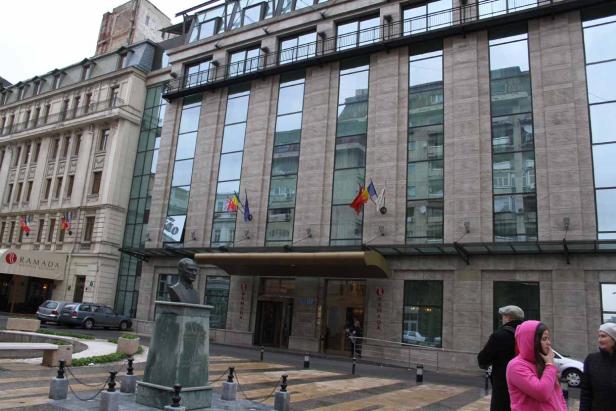 Das Ramada Hotel in Bukarest mit einer Büste davor.