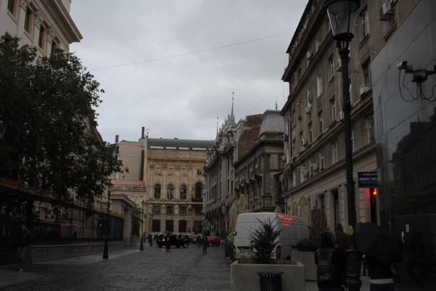 Eine Straße in einer europäischen Stadt mit Kopfsteinpflaster und alten Gebäuden.