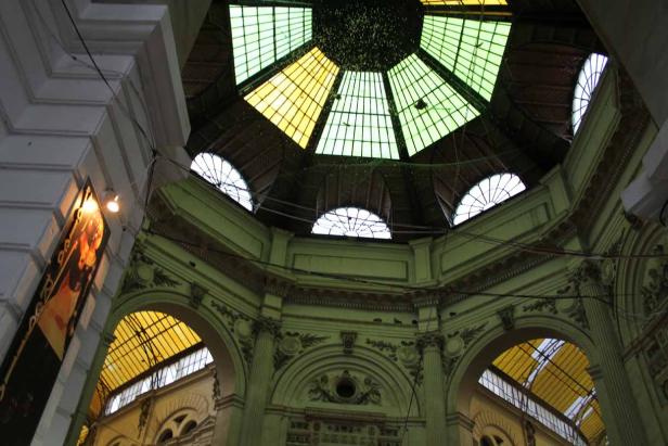 Blick auf die kunstvolle Kuppel eines Gebäudes mit farbigen Glasfenstern.