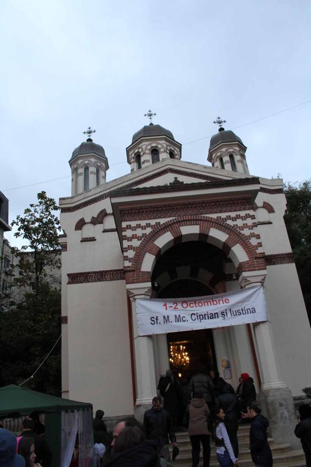 Eine Kirche mit einem Banner für St. Cyprian und Justina über dem Eingang.