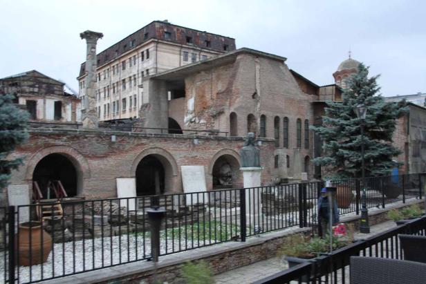 Die Ruinen des Palastes von Bukarest mit einer Statue und einer alten Säule.