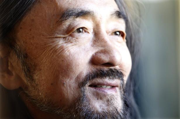 Nahaufnahme eines Mannes mit Bart, der nach oben blickt.