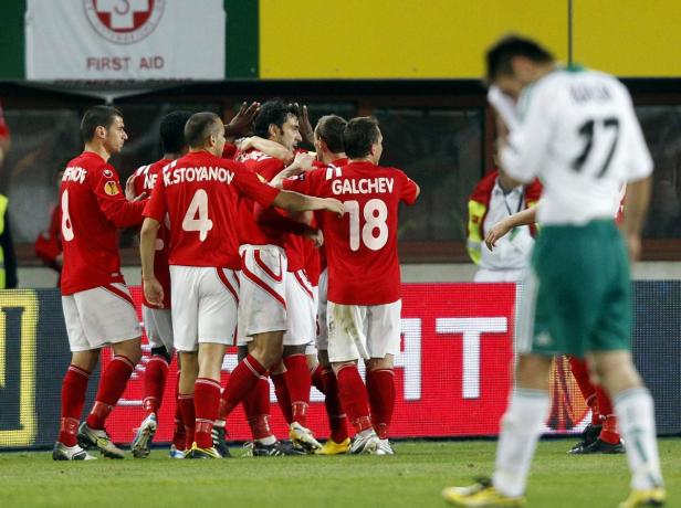 Eine Gruppe Fußballspieler in roten Trikots feiert ein Tor.