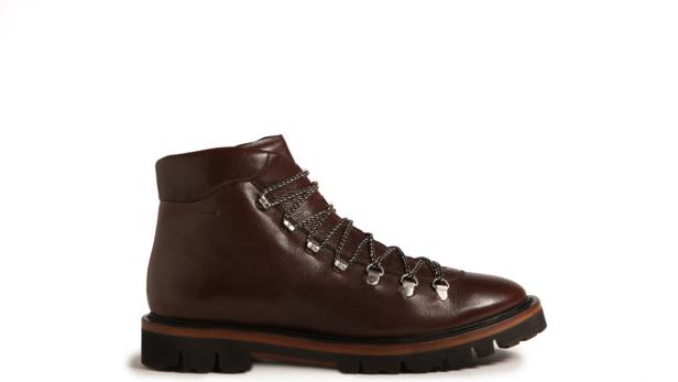 Ein brauner Lederstiefel mit Schnürsenkeln und dicker Sohle steht vor einem weißen Hintergrund.