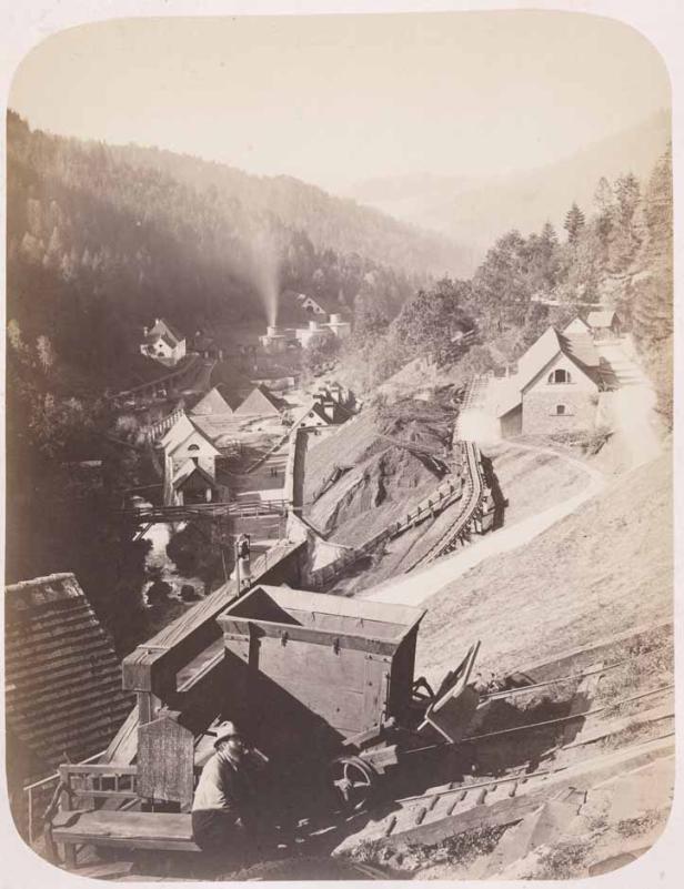Historische Aufnahme einer Bergbauanlage in einer bewaldeten Hügellandschaft.