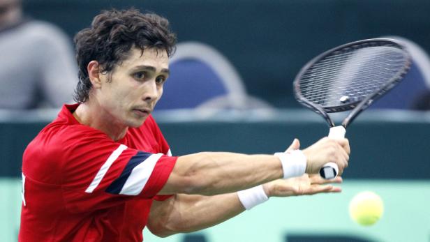 Ein Tennisspieler schlägt einen gelben Tennisball mit seinem Schläger.