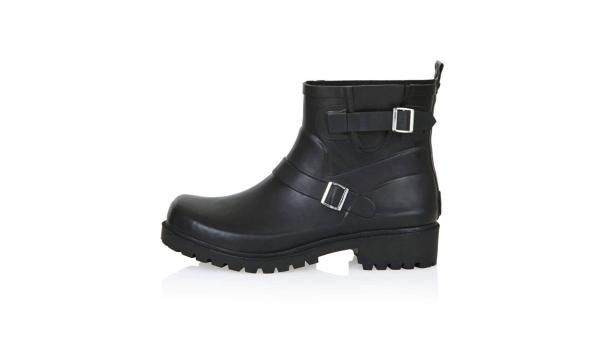 Ein schwarzer Gummistiefel im Biker-Stil mit Schnallen vor einem weißen Hintergrund.