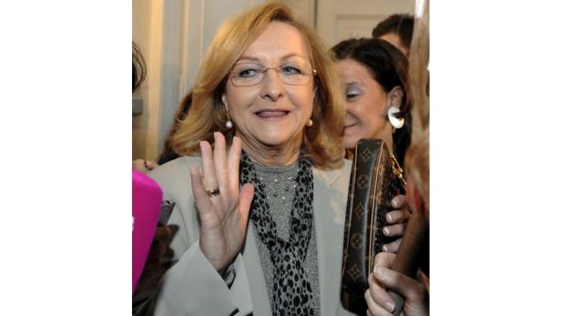 Finanzministerin Maria Fekter Eine Frau mit Brille winkt in die Kamera und hält eine Handtasche.