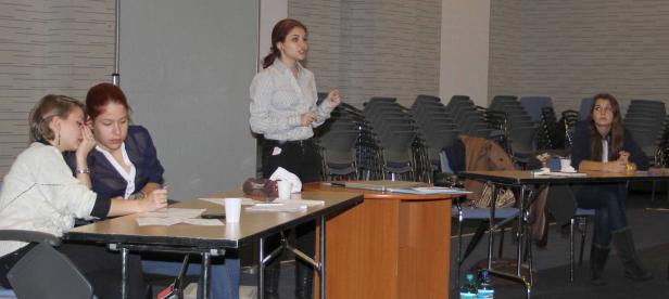 Eine Frau hält einen Vortrag vor einem Publikum in einem Konferenzraum.