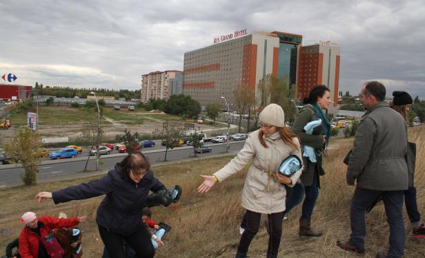 Eine Gruppe von Menschen geht auf einem Hügel in der Nähe des Rin Grand Hotels entlang.