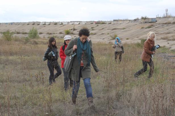 Eine Gruppe von Frauen wandert durch ein Feld mit trockenem Gras.