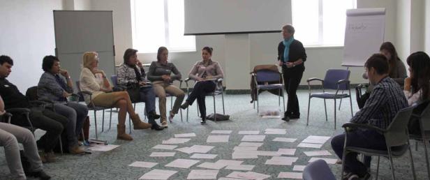 Eine Gruppe von Menschen sitzt im Kreis während einer Präsentation.