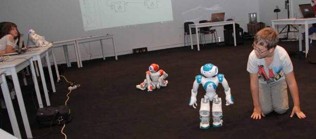 Kinder lassen Roboter aufstehen, winken und ein Quadrat gehen