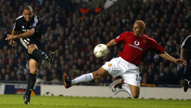 Ronaldo versucht, den Ball an einem Spieler von Manchester United vorbeizuschießen.