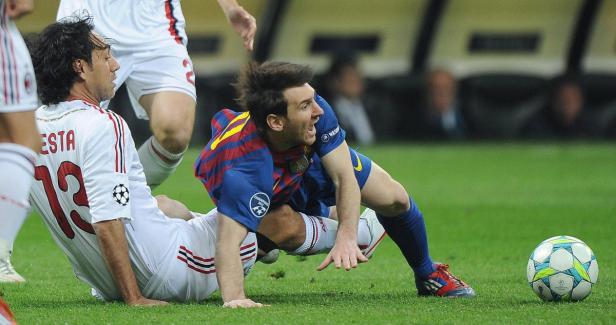 Lionel Messi liegt im Zweikampf mit Alessandro Nesta auf dem Rasen.