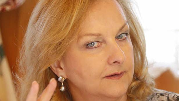 Porträt einer Frau mit blonden Haaren und einem Ohrring.