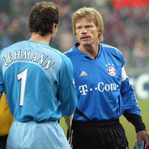 Oliver Kahn spricht mit Jens Lehmann auf dem Fußballfeld.
