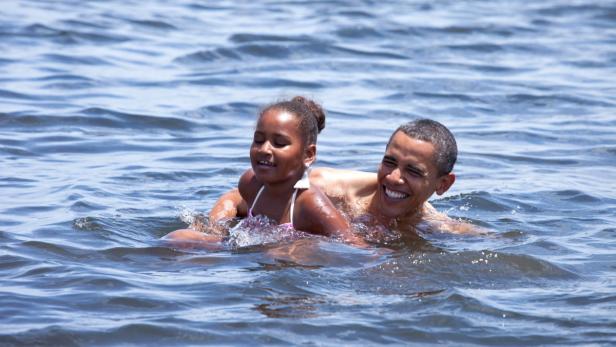 Barack Obama schwimmt mit seiner Tochter im Wasser.