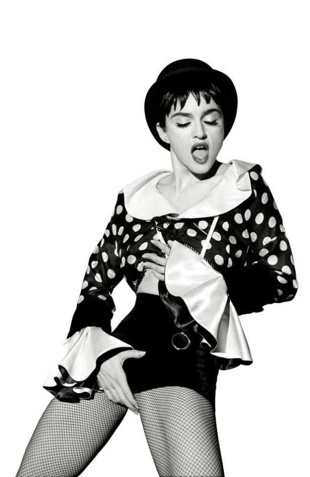 Madonna in einem gepunkteten Oberteil, Shorts und Netzstrumpfhosen, mit Hut.