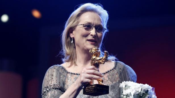 Meryl Streep hält eine goldene Berlinale-Trophäe in den Händen.