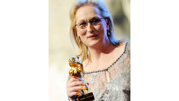 Meryl Streep hält eine goldene Statue in der Hand.