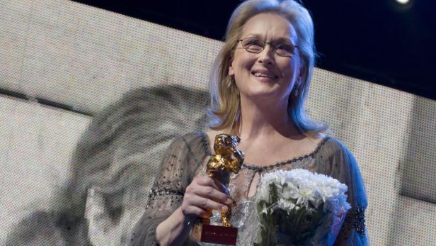 Meryl Streep mit dem Goldenen Ehrenbären der Berlinale und einem Blumenstrauß.